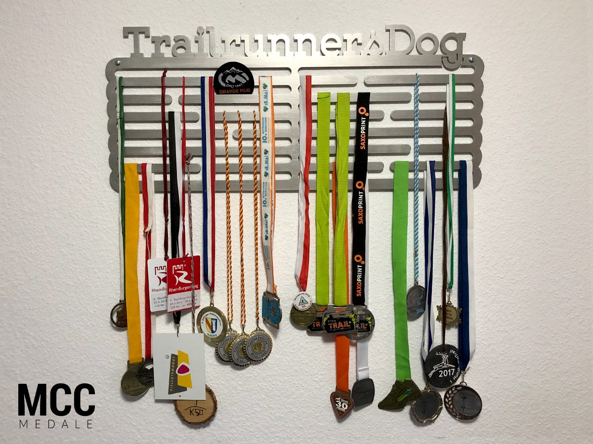 Wieszak do eksponowania medali sportowych w domu z zawieszonymi medalami na szarfach
